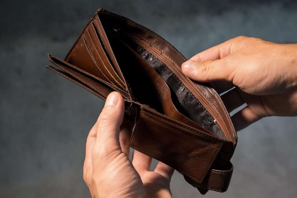 Hands holding open a brown wallet